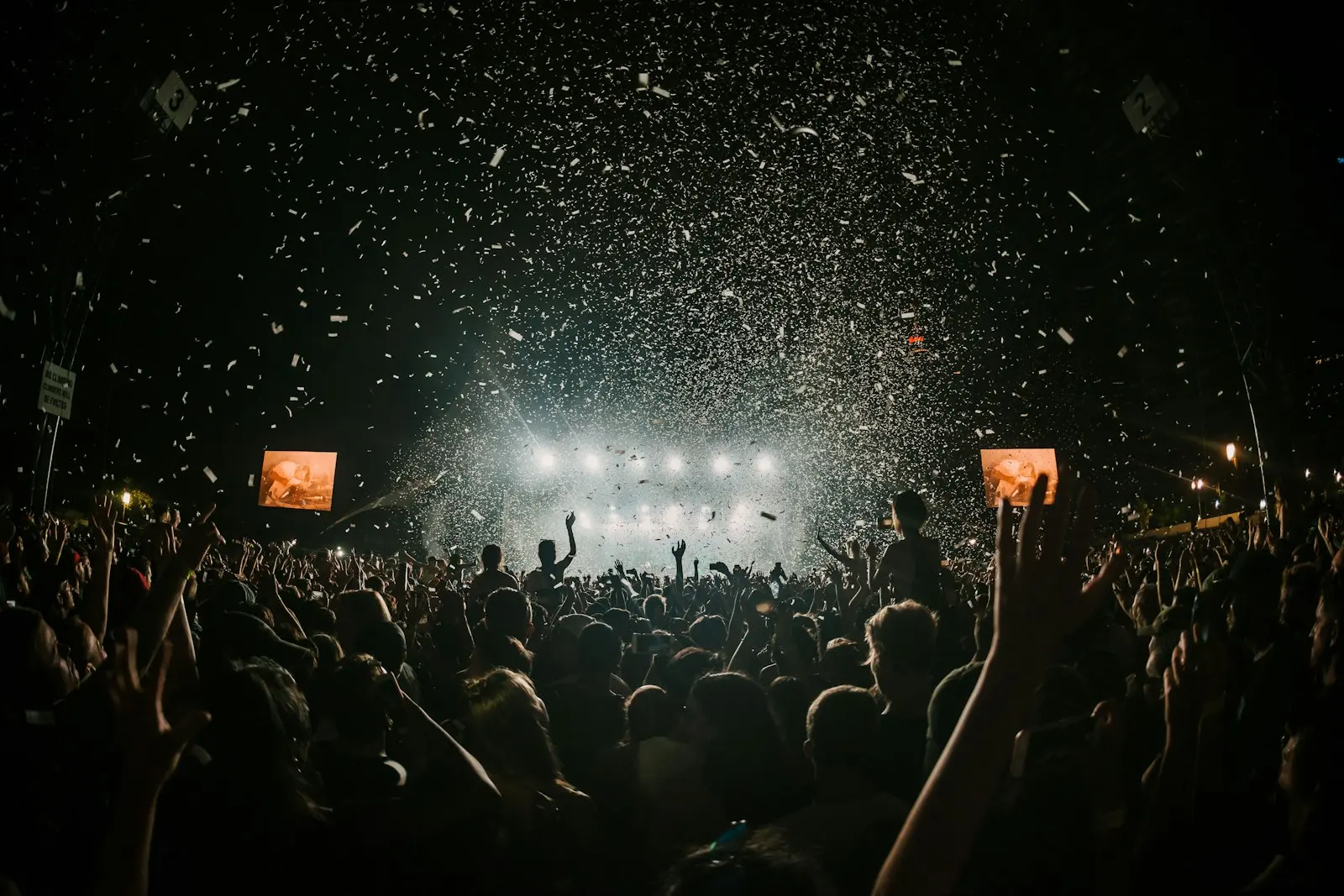 Festival crowd celebrating in front of a night stage