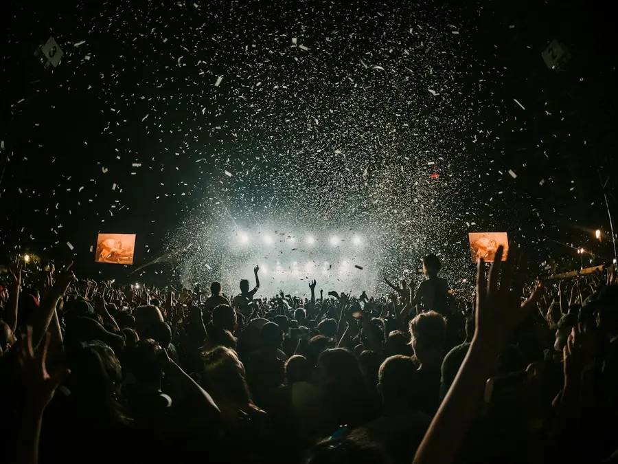 Festival crowd celebrating in front of a night stage